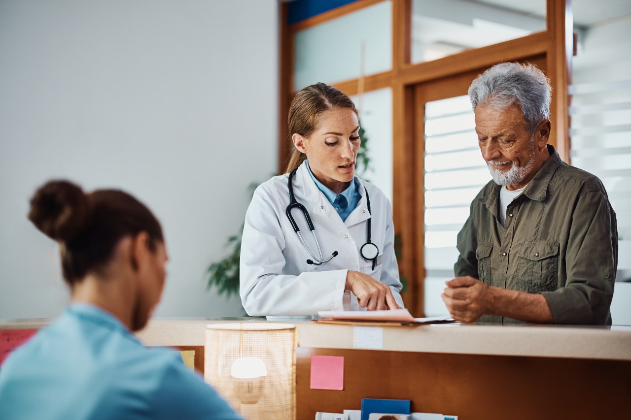 Doctor and consulting with patient at doctor's office counter