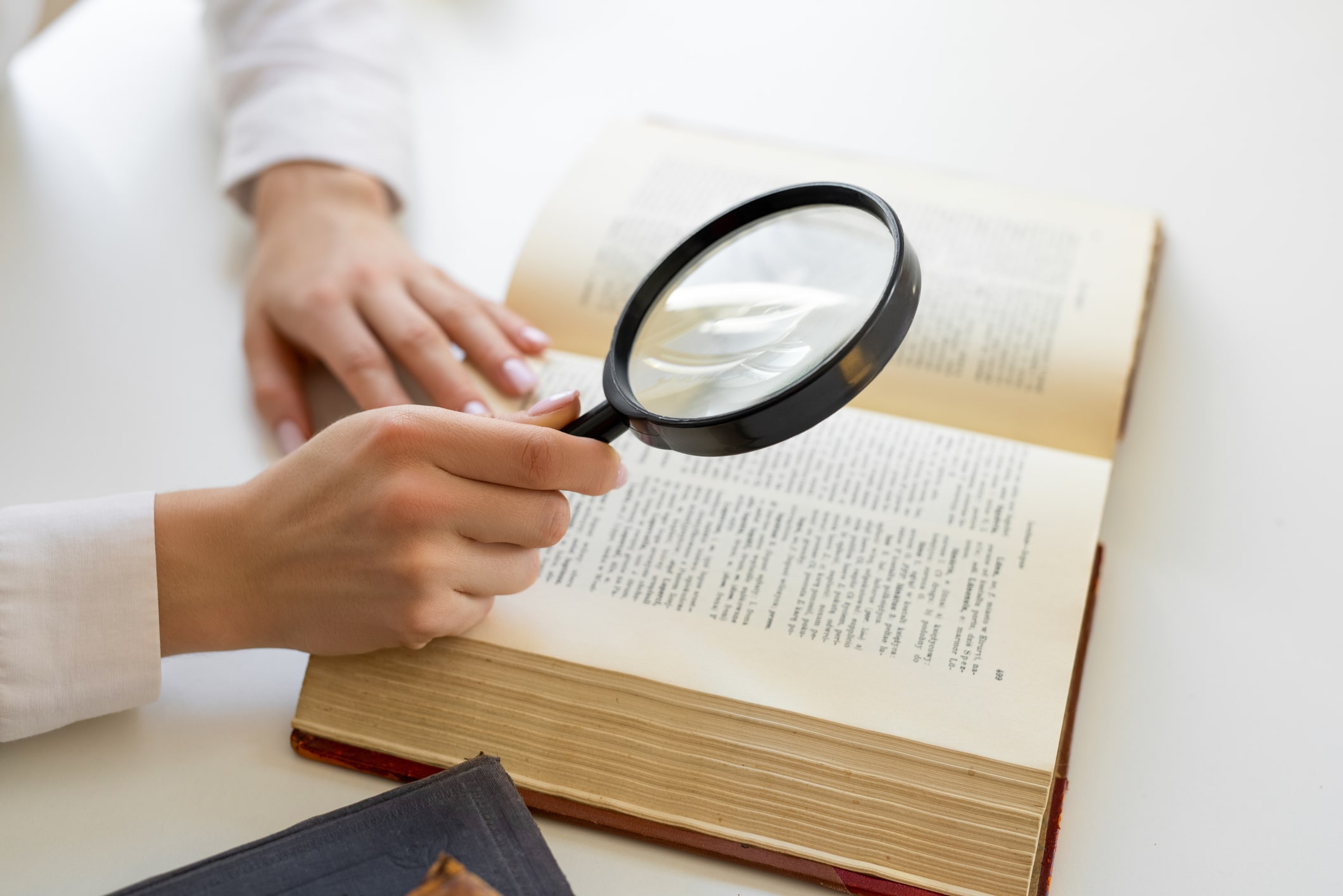Magnify glass held over dictionary
