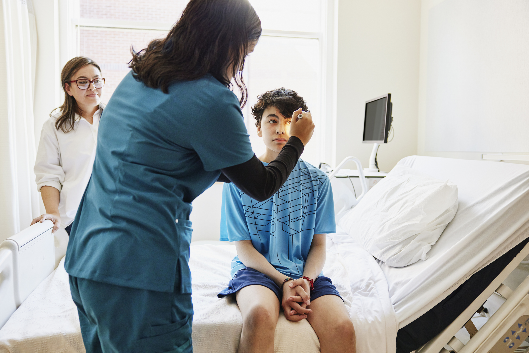 Primary Care Physician Performing a Routine Eye Exam on a Young Male Patient 