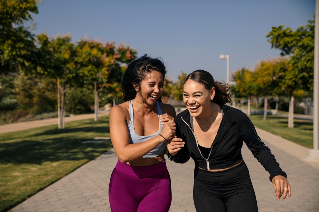 Two women jogging and laughing
