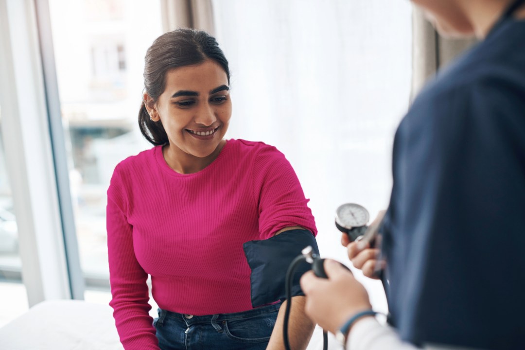 Woman getting her blood pressure checked by a medical professional