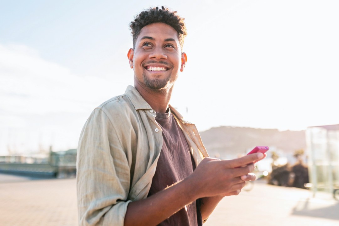 Man holding his phone look over his shoulder