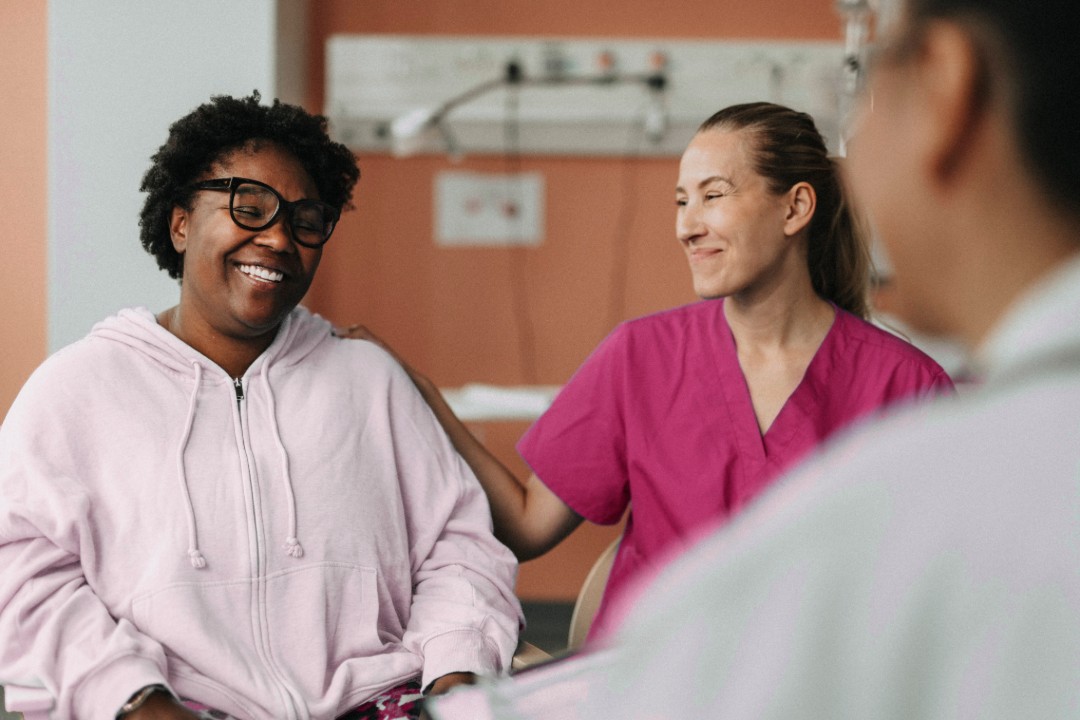 African American woman being comfortable by a medical professional in a doctor's office
